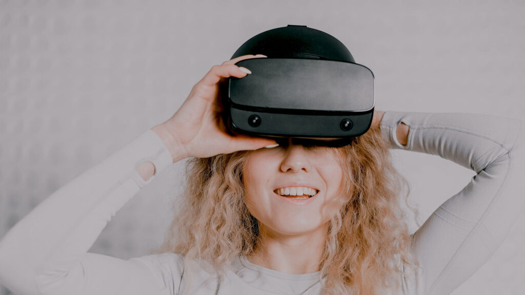 Photo d'une femme avec un casque de réalité virtuelle. Cette dernière peut être utiliser pour améliorer le processus d'enseignement.