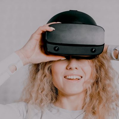 Photo d'une femme avec un casque de réalité virtuelle. Cette dernière peut être utiliser pour améliorer le processus d'enseignement.
